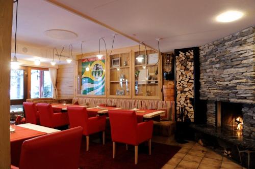 a restaurant with tables and chairs and a fireplace at Hotel Schützen Lauterbrunnen in Lauterbrunnen