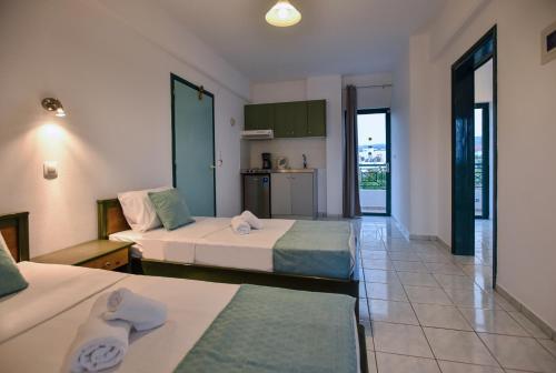 een hotelkamer met twee bedden en een keuken bij Villa Maria Apts in Kato Gouves