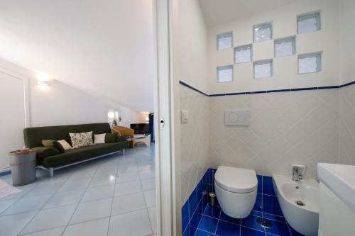 een badkamer met een toilet en een bank bij La Mansarda in Praiano