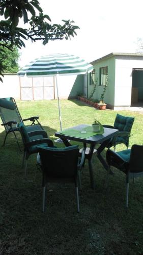 a table and chairs with an umbrella in the grass at Lelita in Bela Crkva