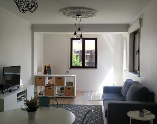 ein Wohnzimmer mit einem blauen Sofa und einem Tisch in der Unterkunft Amália Rodrigues -apartamento com 3 quartos em pleno coração de Ílhavo in Ílhavo