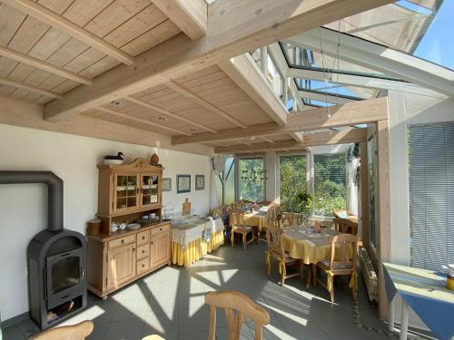 een grote eetkamer met tafels en een fornuis bij Pension-Ferienwohnung Liesbachtal direkt am Waldrand Bayerische Rhön in Schönau an der Brend