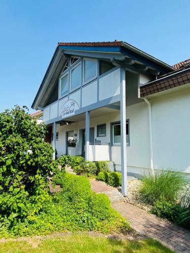 a white house with the ocean in the background at Pension-Ferienwohnung Liesbachtal direkt am Waldrand Bayerische Rhön in Schönau an der Brend