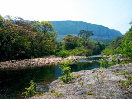 une rivière avec des rochers et des arbres en arrière-plan dans l'établissement Pousada Vale da Canastra, à São José do Barreiro