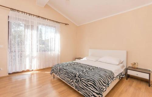 a bedroom with a bed and a large window at Apartmani Andrija in Pakoštane