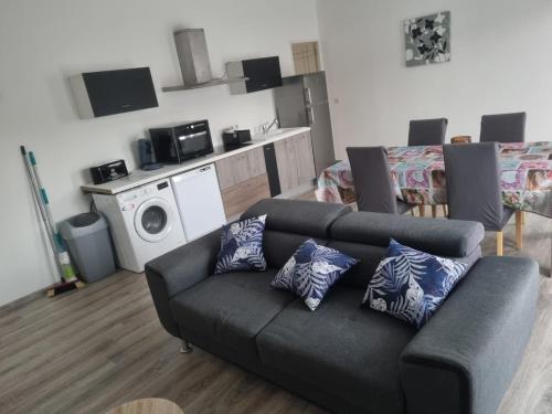 a living room with a couch with pillows on it at Appartement séjour , cure Cransac au 1er étage 2 nuits minimum in Cransac