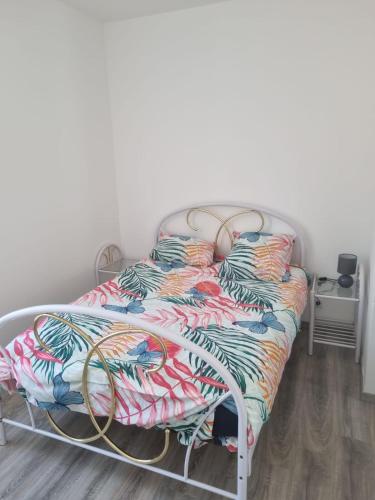 une chambre avec un lit avec une couette colorée dans l'établissement Appartement séjour , cure Cransac au 1er étage 2 nuits minimum, à Cransac