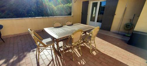 Une table et des chaises en bois sont disponibles sur la terrasse. dans l'établissement Chambre avec terrasse, à Sarrians