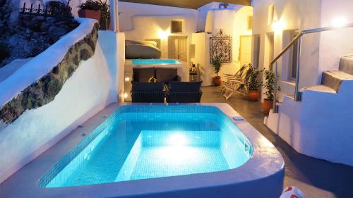 a swimming pool in the middle of a house at Aqua & Terra Traditional Cave Houses in Oia