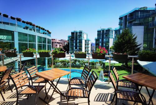 a patio with tables and chairs and a pool at F 207 Primorsko del Sol - просторно студио с кухня in Primorsko