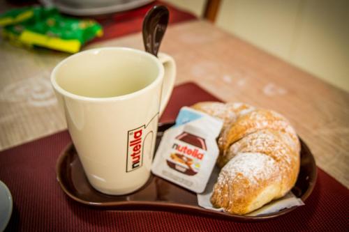 een bord met een kopje koffie en een gebakje bij Respice Stellam casa vacanza in Castellaneta