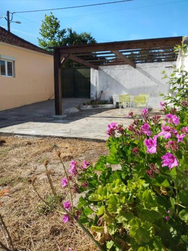 a garden with pink flowers in front of a building at Casa Júlia in Fonte Errada