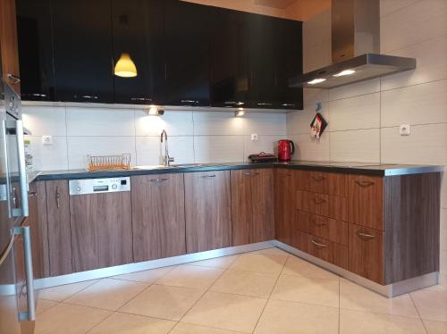 a kitchen with wooden cabinets and a black counter top at Lazy Farm II in Marathón