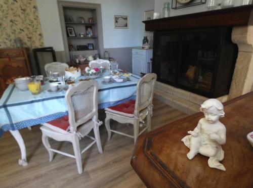 a living room with a table and chairs and a fireplace at La Maison Florence in Mont-de-Marsan