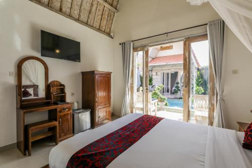 a bedroom with a bed and a tv and a window at The Box Paradise Cottage in Nusa Penida