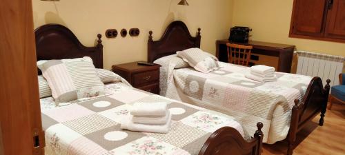 1 dormitorio con 2 camas y toallas. en Casa de Aldea El Boje, 