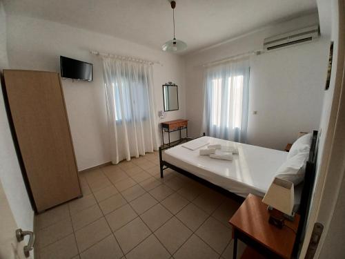 a room with a bed and a tv in it at Taxiarchis Studios in Áyios Yeóryios