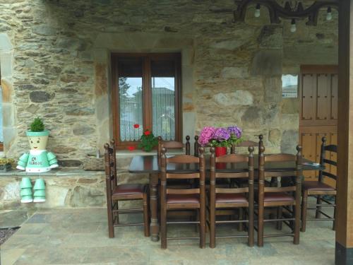 Casa de piedra con mesa y sillas en Casa de Aldea El Boje 