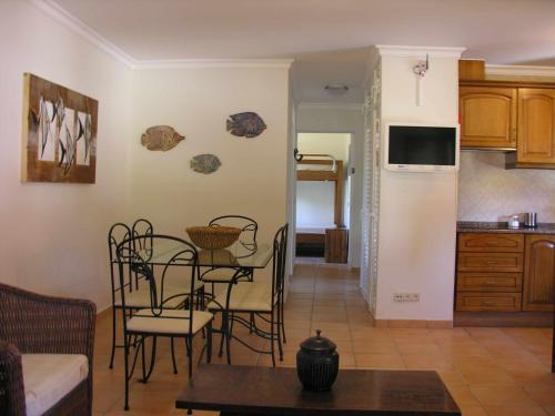 ein Wohnzimmer mit einem Tisch und Stühlen sowie eine Küche in der Unterkunft Retur Algarve Beach House in Castro Marim