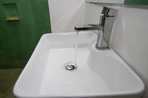 lavabo blanco con grifo en el baño en King Boutique Hotel, en Siem Reap