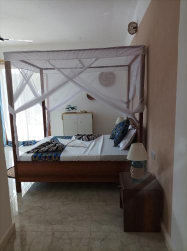 a bedroom with a canopy bed in a room at Zanzicrown in Nungwi