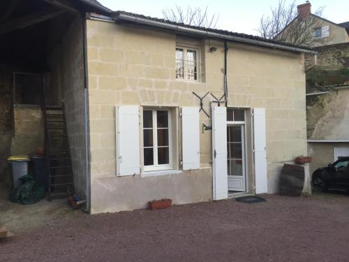 a house with two white doors and a garage at Maison au carrefour des terroirs in Pouançay