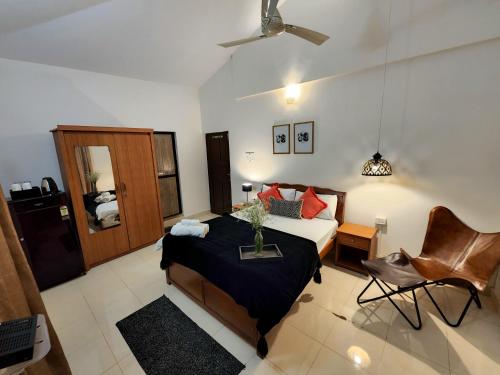 a bedroom with a bed and a chair in it at Casa Casita Candolim in Candolim