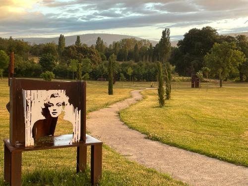 a painting of a woman on a sign in a field at casa rural de un artista en plena naturaleza piscina y parque de esculturas en villarcayo in Villarcayo