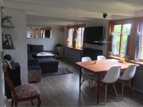 ein Wohnzimmer mit einem Tisch und einem Sofa in der Unterkunft Turf House Cottage - Near Airport in Miðvágur