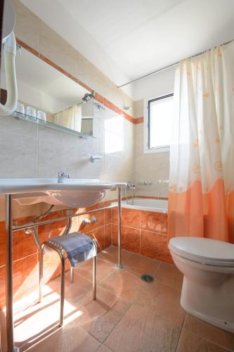 a bathroom with a sink and a toilet and a tub at Hotel Akti Arilla in Arillas