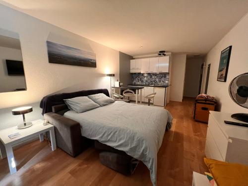 a bedroom with a bed and a kitchen at L'océan à perte de vue, la grande plage à vos pieds in Biarritz