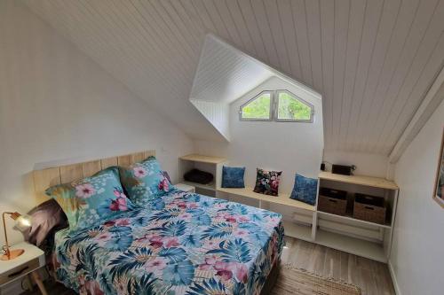 um quarto com uma cama num sótão com uma janela em Appartement 500 mètres de la plage à GOSIER em Le Gosier
