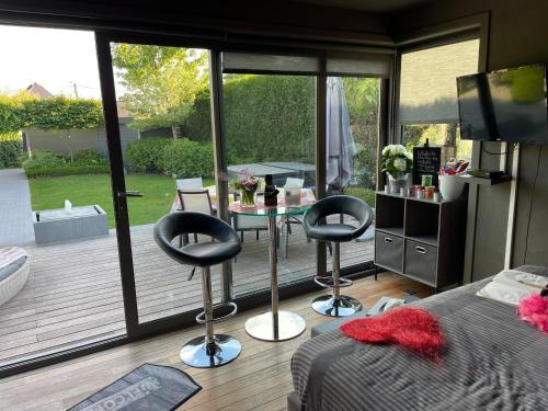 a bedroom with a balcony with a table and two chairs at La chambre du puits avec 2 jacuzzis , sauna et Hammam privatif in Tournai