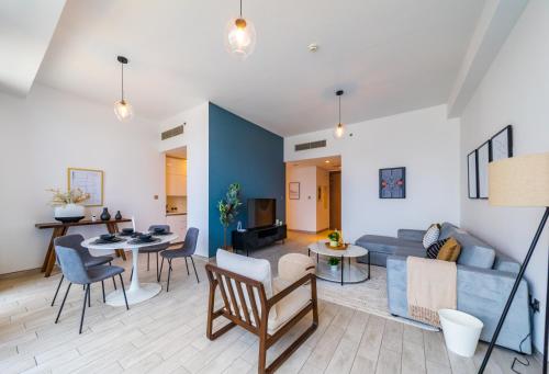 a living room with a blue couch and a table at EDEN'S Homes & Villas - Atria Residences in Dubai