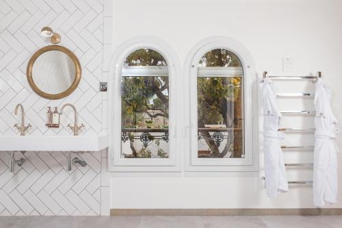 - une salle de bains blanche avec deux fenêtres et un miroir dans l'établissement Hôtel Le Saint Remy & Spa, à Saint-Rémy-de-Provence