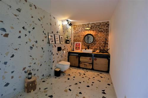 a bathroom with a toilet and a brick wall at Apartament Old School in Ustronie Morskie