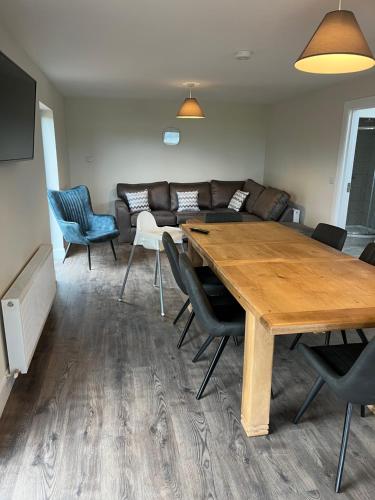 a living room with a wooden table and chairs at Oakwell holiday village in Ramelton