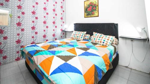 巴圖的住宿－Villa Aviation by Masterpiece Villa，一间卧室配有一张带五颜六色棉被的床