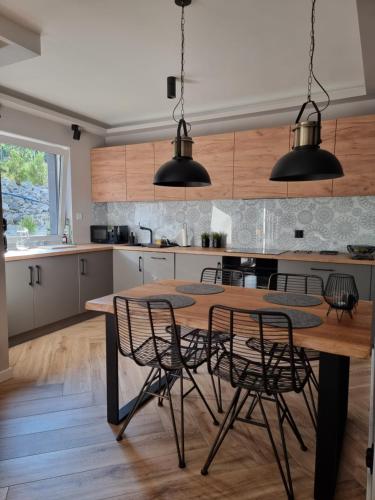 cocina con mesa de madera y sillas en Apartament Wiślańskie Skije, en Wisła