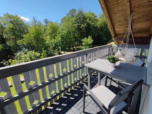 eine Terrasse mit einem Tisch und Stühlen auf dem Balkon in der Unterkunft Lake House Sebanc in Bled