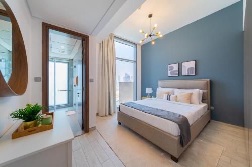 a bedroom with a large bed with blue walls at EDEN'S Homes & Villas - Atria Residences in Dubai