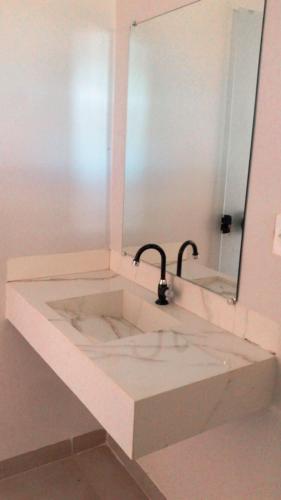 a bathroom with a sink and a mirror at Pousada Flor de Lótus in São Félix do Tocantins