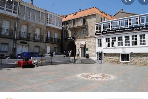 a group of buildings with a courtyard in front at Vivienda 2 sin ascensor in Laxe