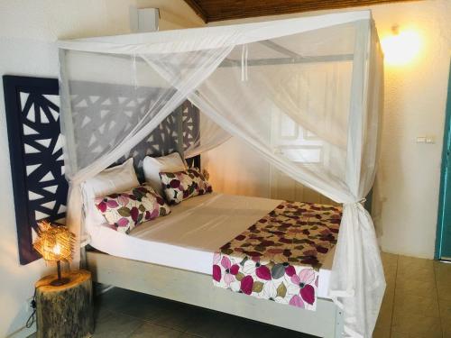a bedroom with a bed with a canopy at West AFRICAN BEACH in Sali Nianiaral