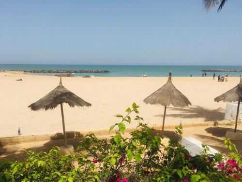 a beach with umbrellas and people on the beach at West AFRICAN BEACH in Sali Nianiaral