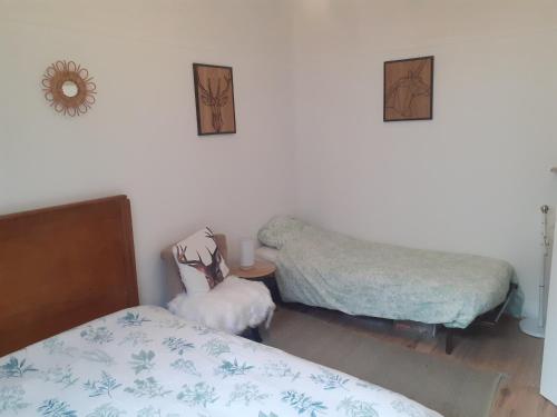 - une chambre avec deux lits et une petite table avec un couvre-lit dans l'établissement Appart agréable, fonctionnel ! Proche commerces !, à La Bourboule