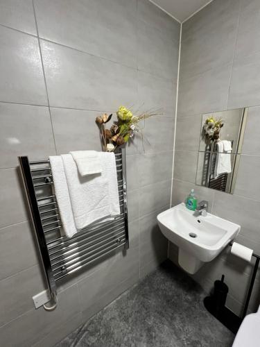 Baño blanco con lavabo y espejo en Spacious 1 bed relocation apartment free parking,, en Brierley Hill