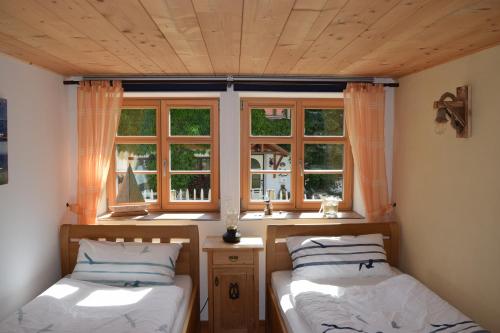 two beds in a room with two windows at Holstein-Höfle, ArgenInsel in Argenbühl