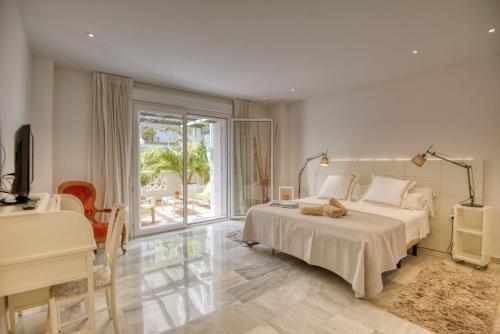 1 dormitorio con cama, escritorio y ventana en PLAYAS DEL DUQUE, PUERTO BANUS, GOLF .PLAYA Y COMPRAS, en Marbella