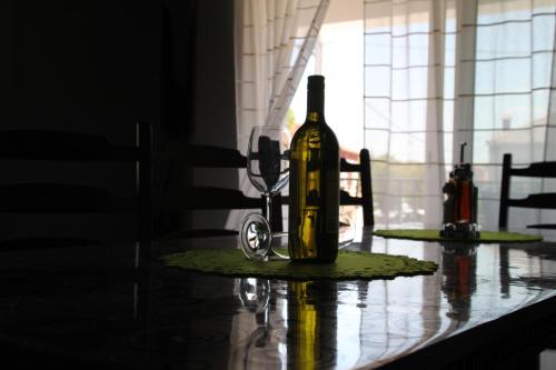 a bottle of wine sitting on a table with a glass at House Tena in Zaton
